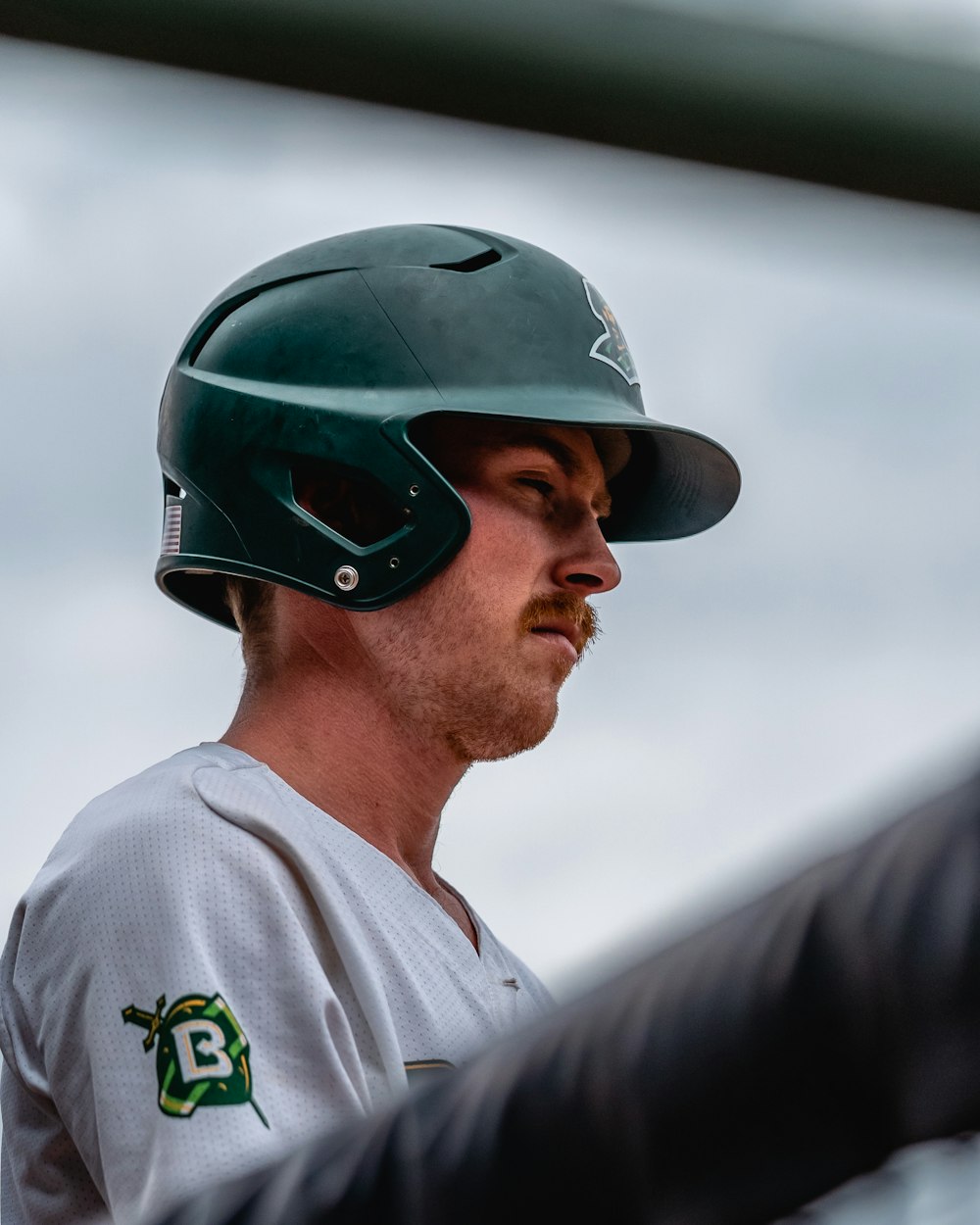 a baseball player wearing a green helmet and holding a bat