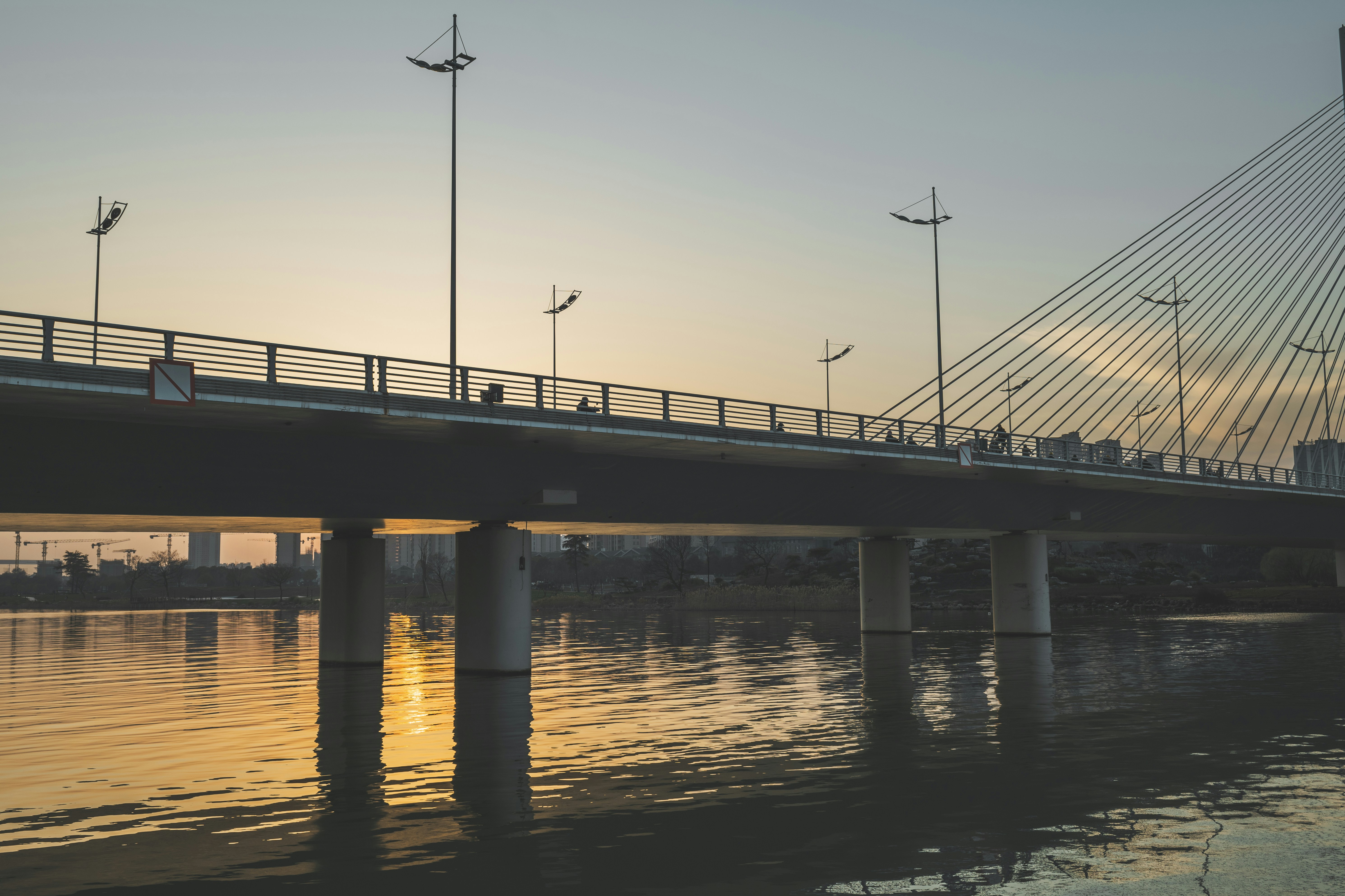 a bridge over a body of water at sunset