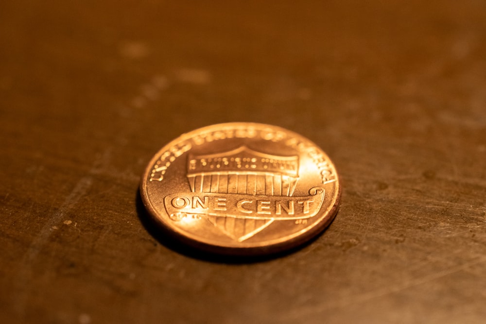 um centavo sentado em cima de uma mesa de madeira