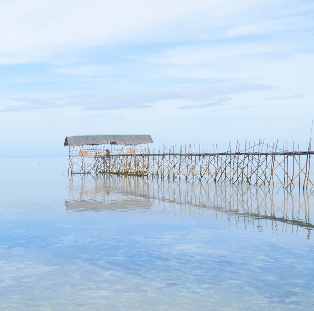 a wooden pier with a hut on top of it