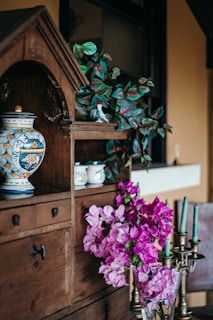 a vase filled with purple flowers sitting on top of a table