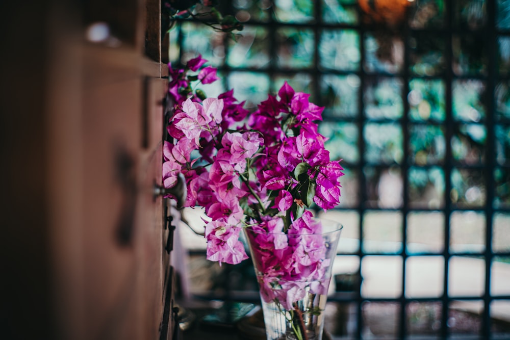 un vase rempli de fleurs violettes assis sur une table