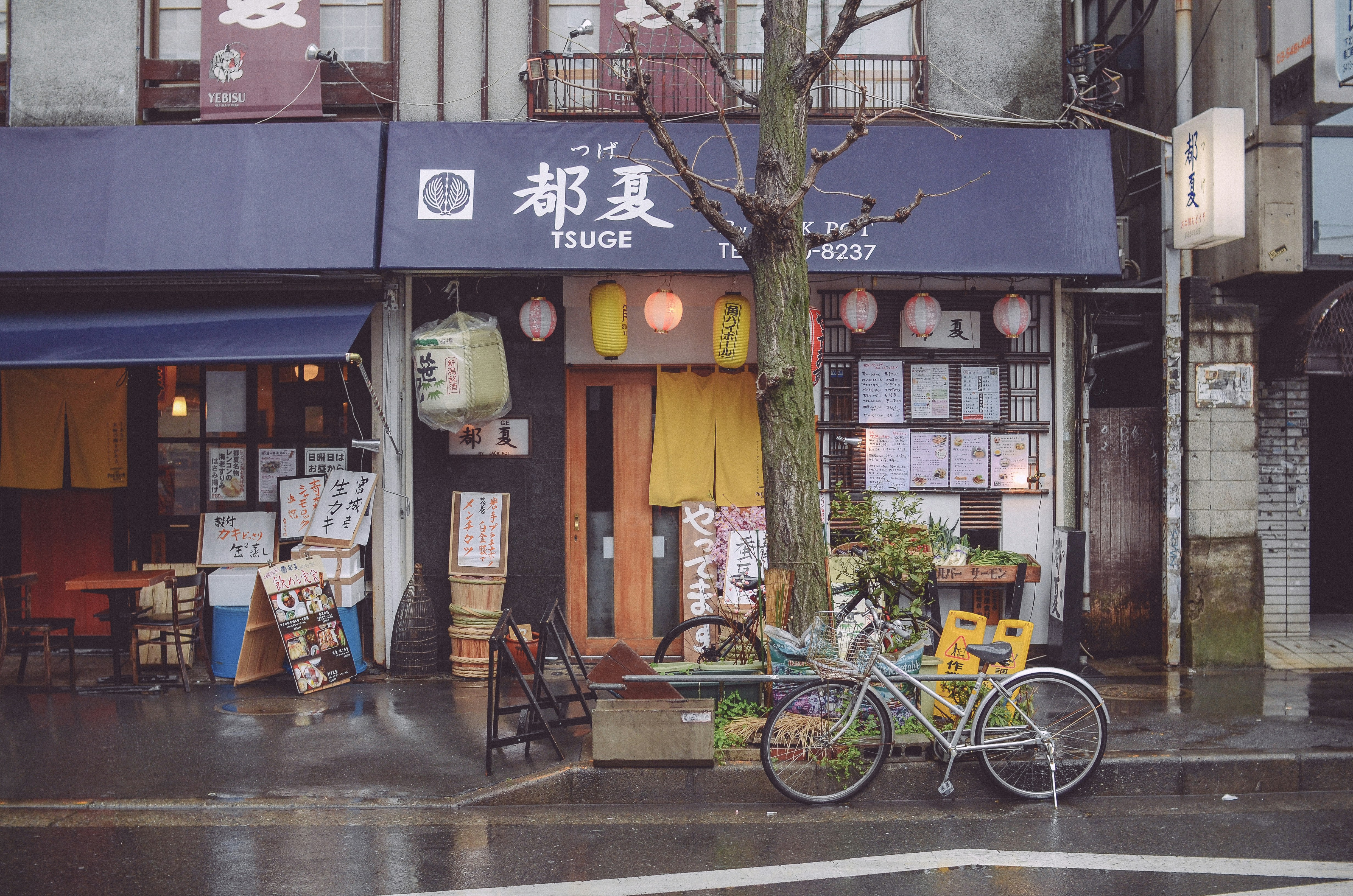 Bicycle parked outside store on rainy day