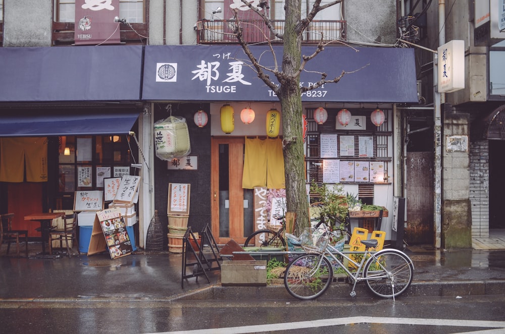 a bicycle parked outside of a store on a rainy day