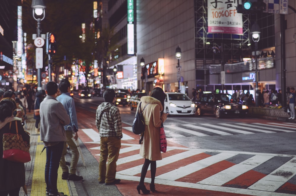 a group of people standing on the side of a street