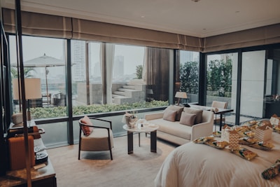 a living area with a couch, chair, table, and windows