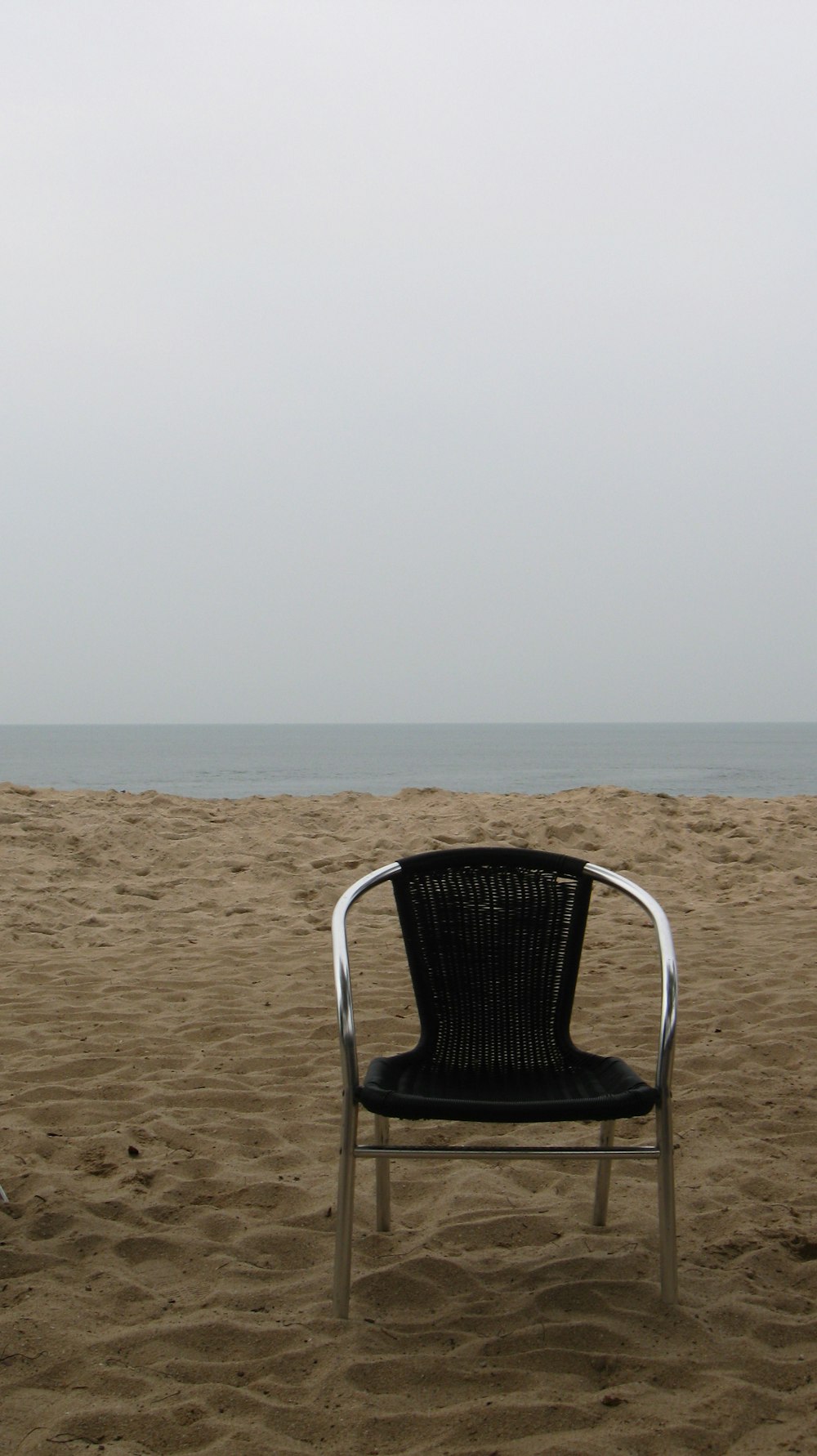a chair sitting on top of a sandy beach
