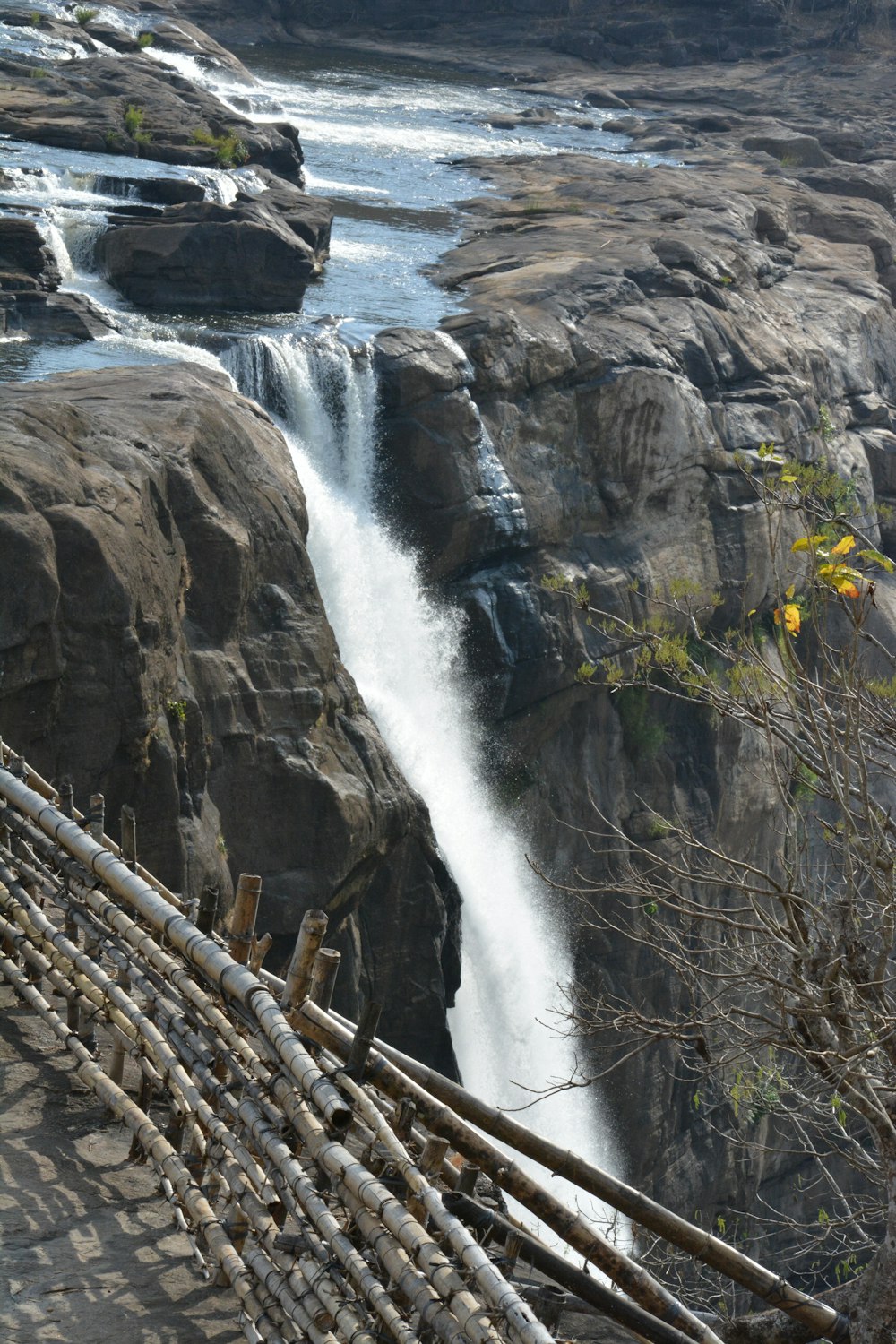 a wooden bench sitting next to a waterfall