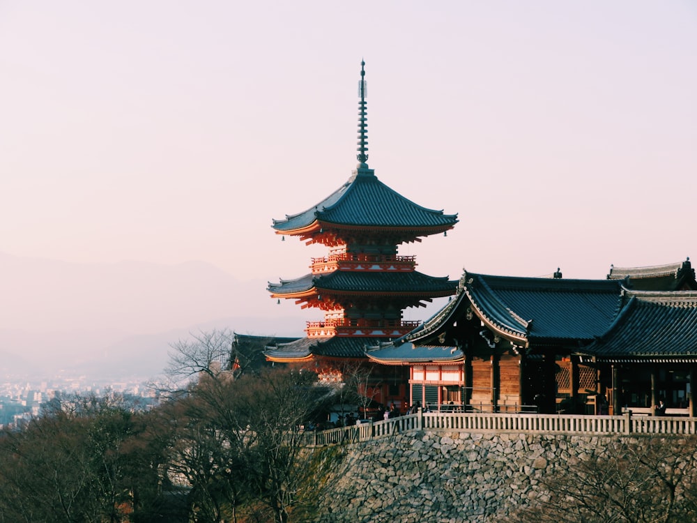 a tall building sitting on top of a lush green hillside