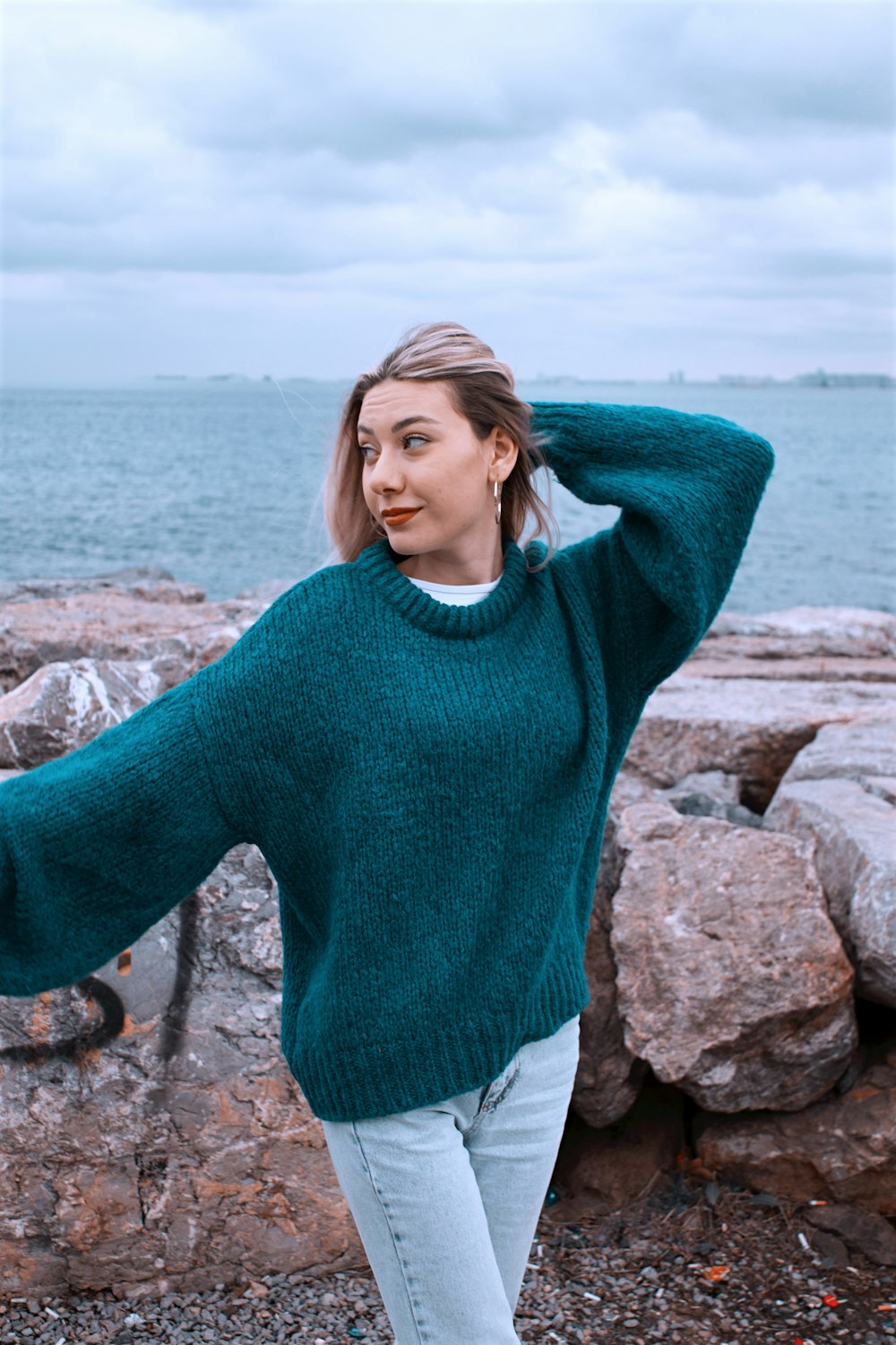 Foto Una mujer con un suéter verde junto al agua – Imagen Azul gratis en  Unsplash