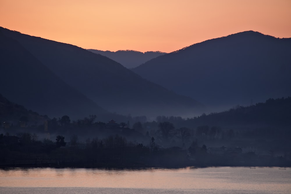 a body of water with mountains in the background