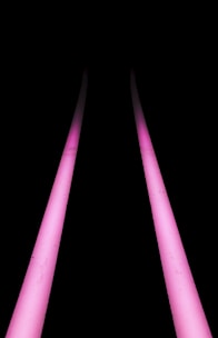 a black background with three pink lights in the dark