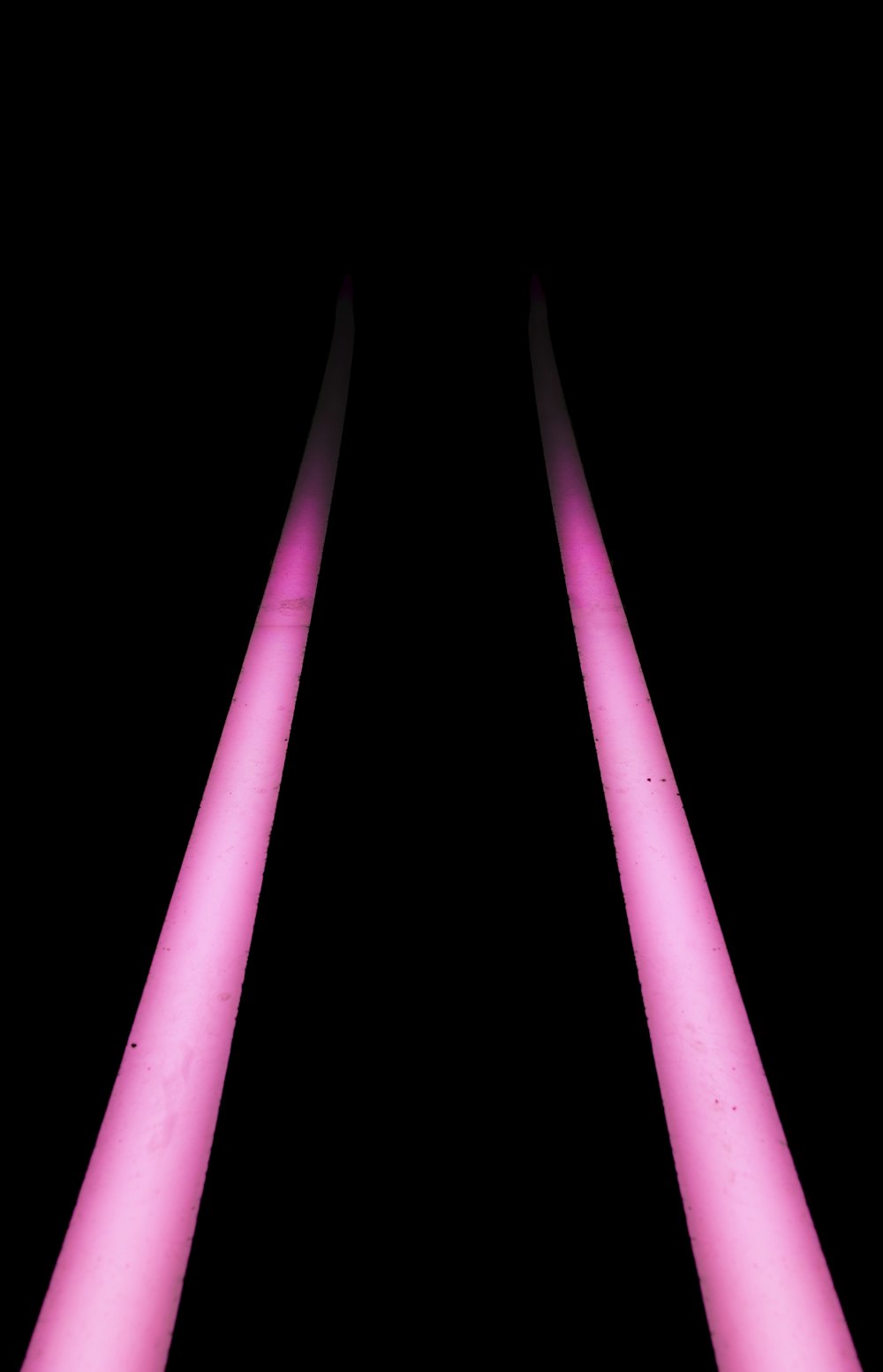 a black background with three pink lights in the dark