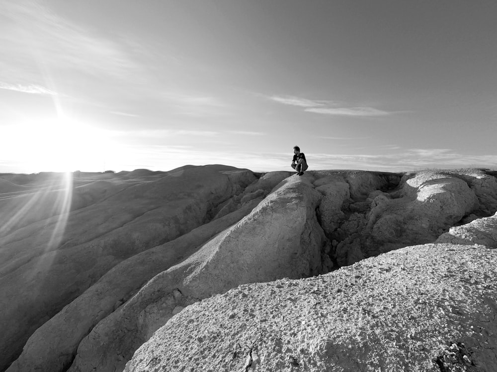 a person sitting on top of a large rock