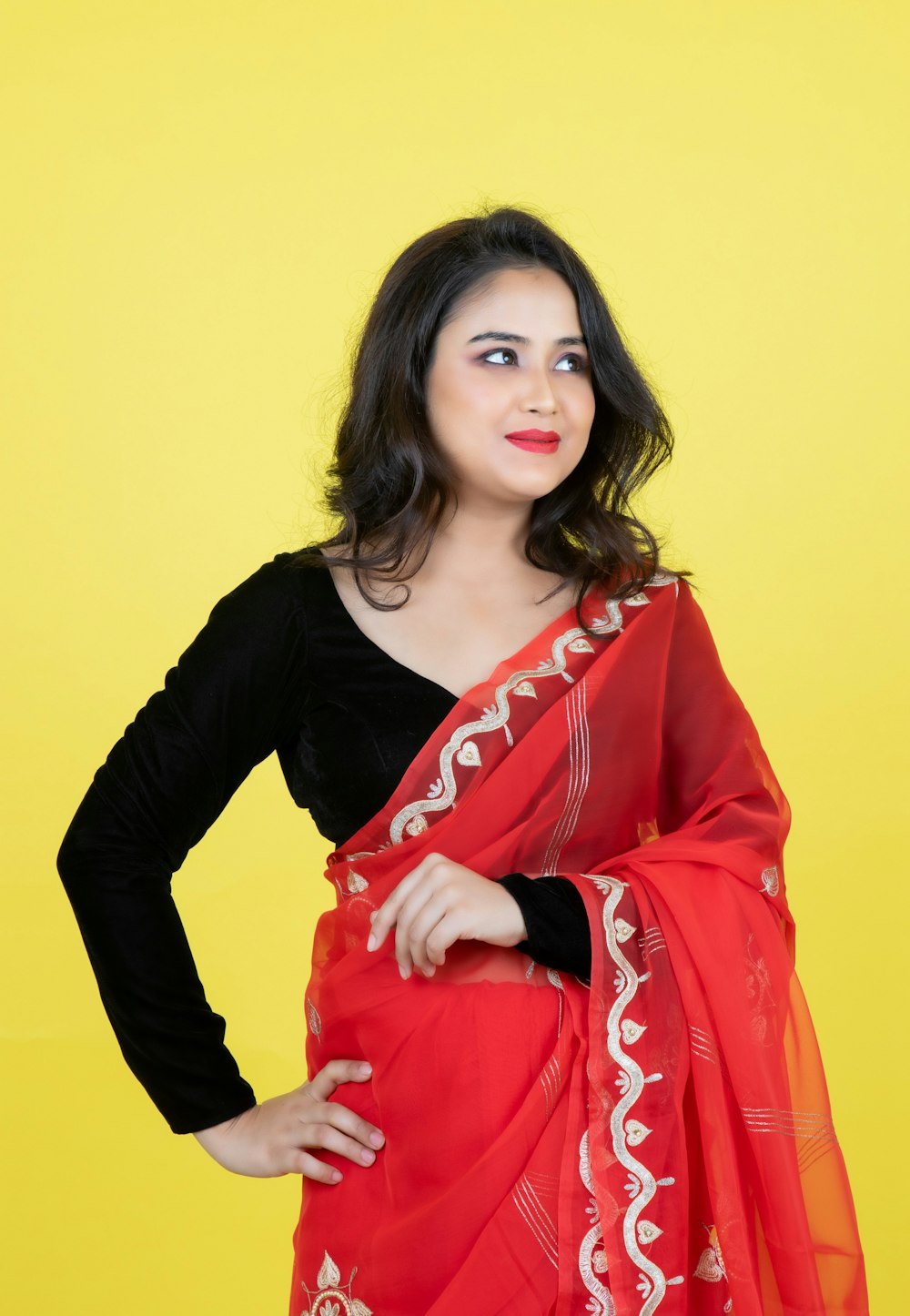 a woman wearing a red and white sari