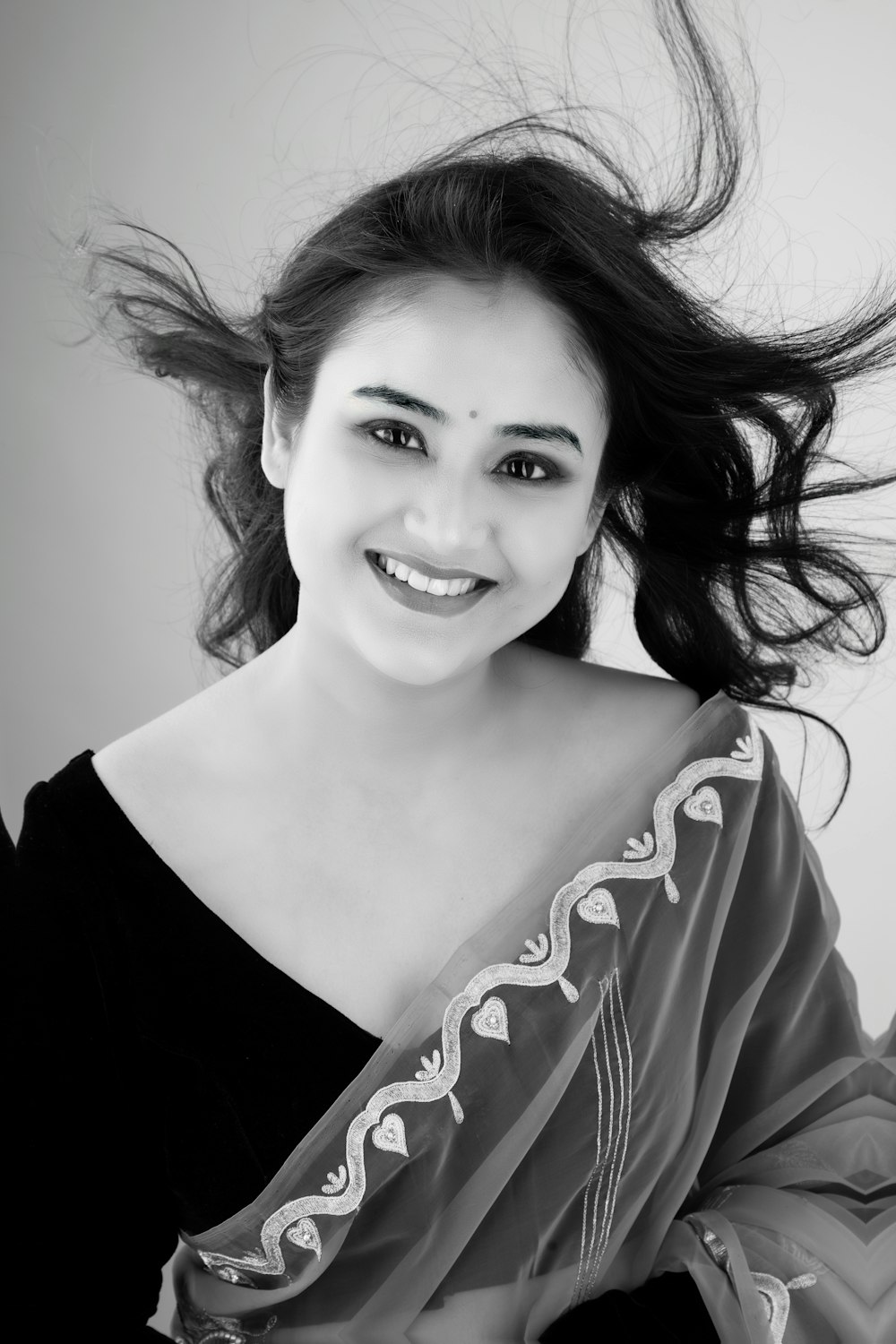 a woman in a black and white photo with her hair blowing in the wind