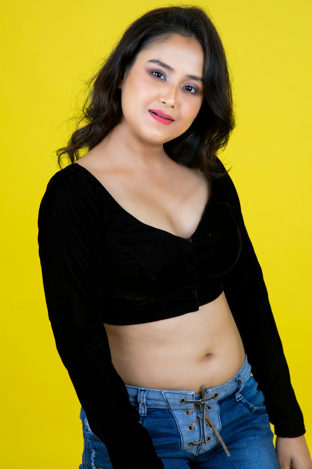 a woman posing for a picture with a yellow background