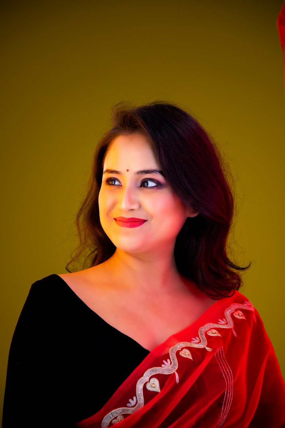 a woman wearing a red shawl and smiling