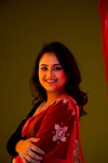 a woman wearing a red saree and smiling