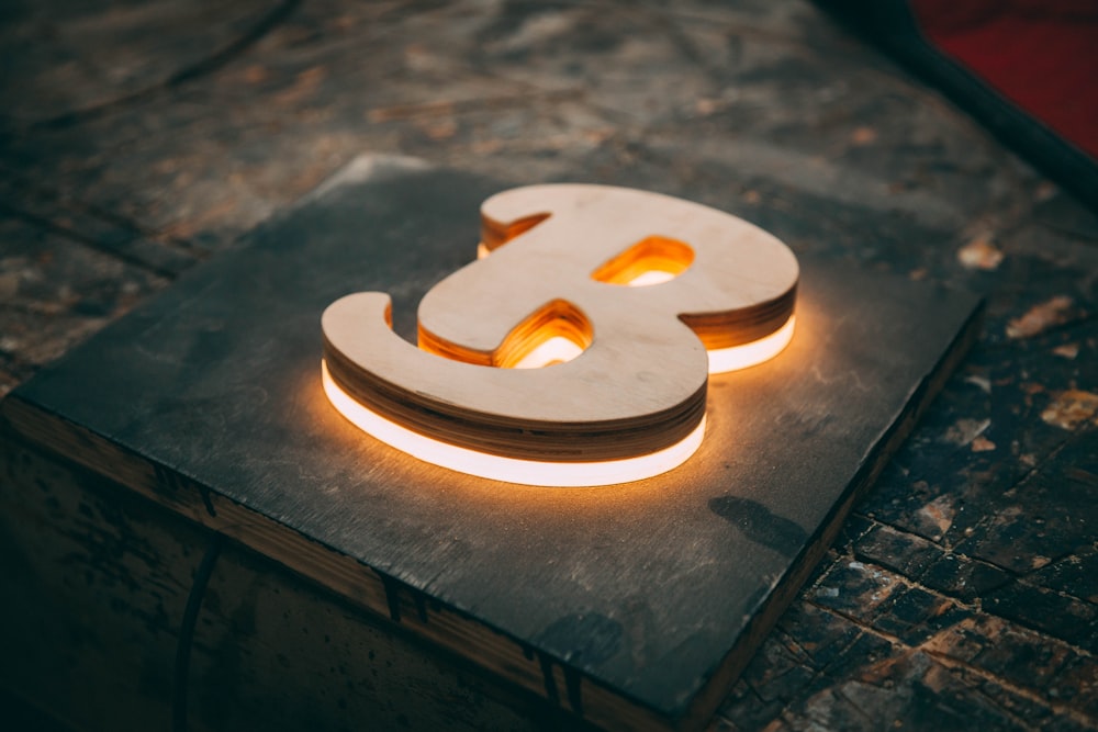 a lit up wooden letter sitting on top of a table
