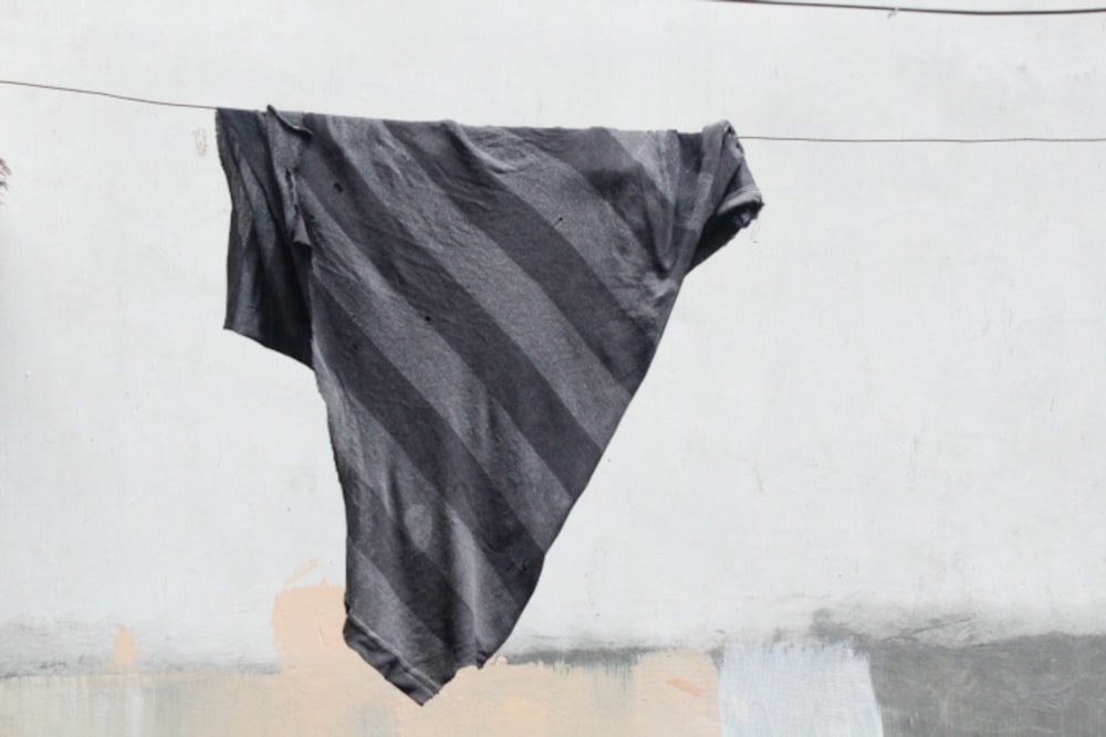 a black and white striped shirt hanging on a clothes line