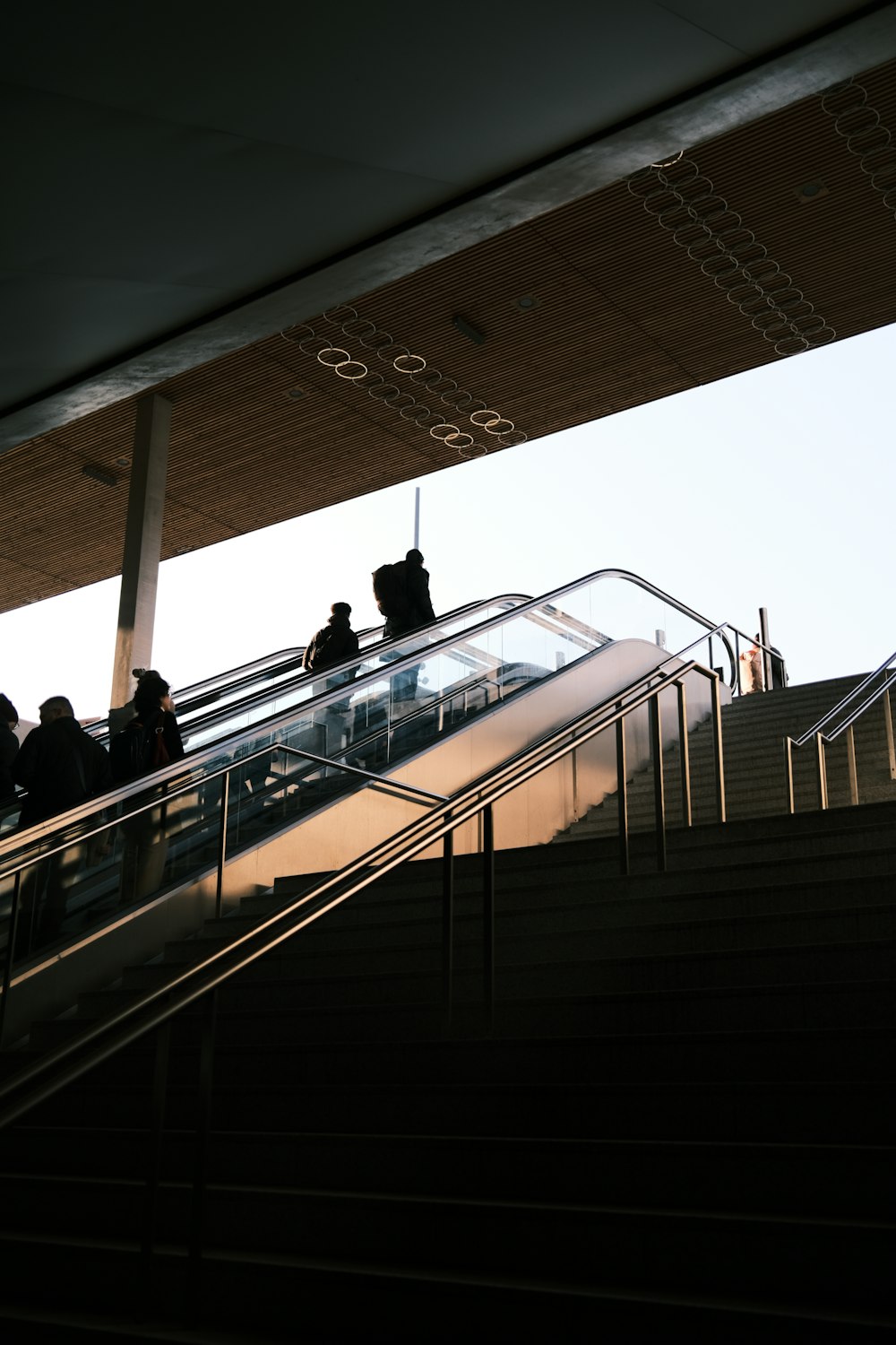 a group of people riding down an escalator