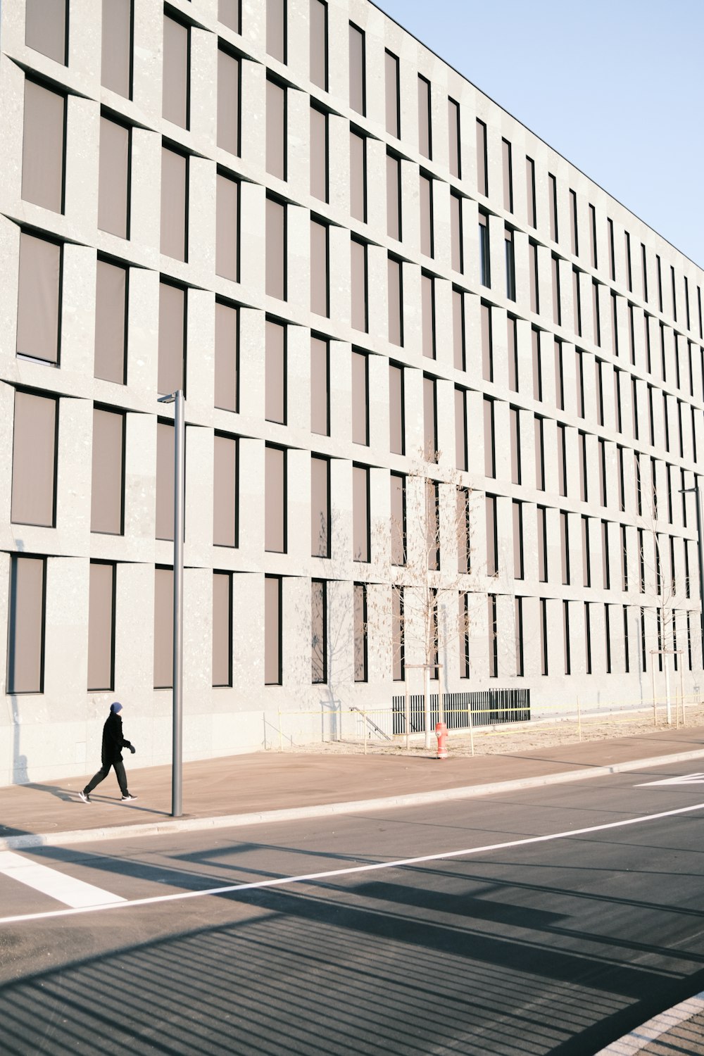 a man walking down a street next to a tall building