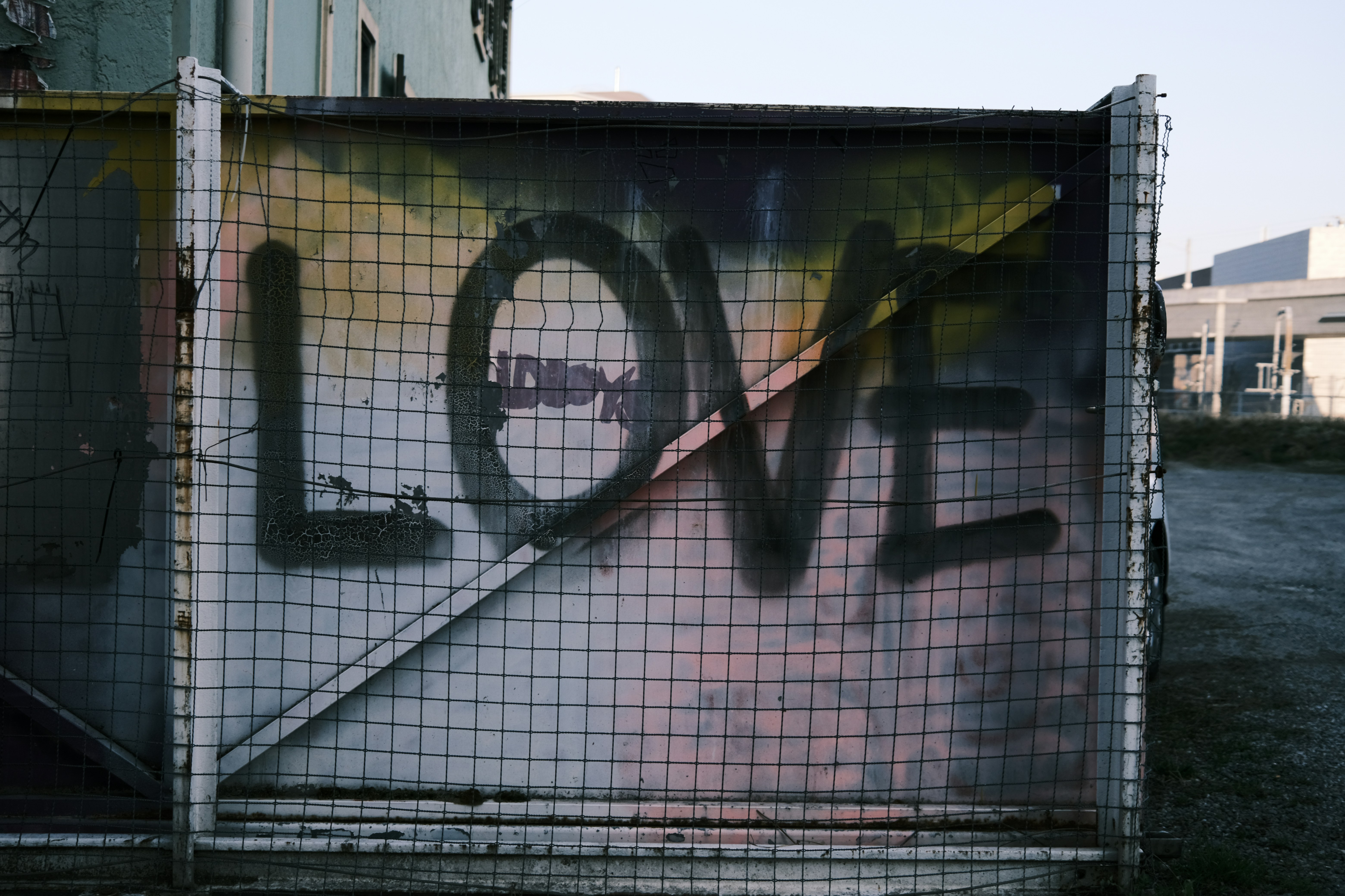 A fence with graffiti on it in front of a building photo – Free Love Image  on Unsplash, image size:3000x2000