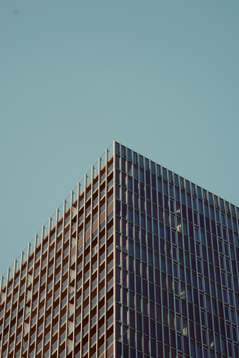 a plane flying in the sky over a tall building