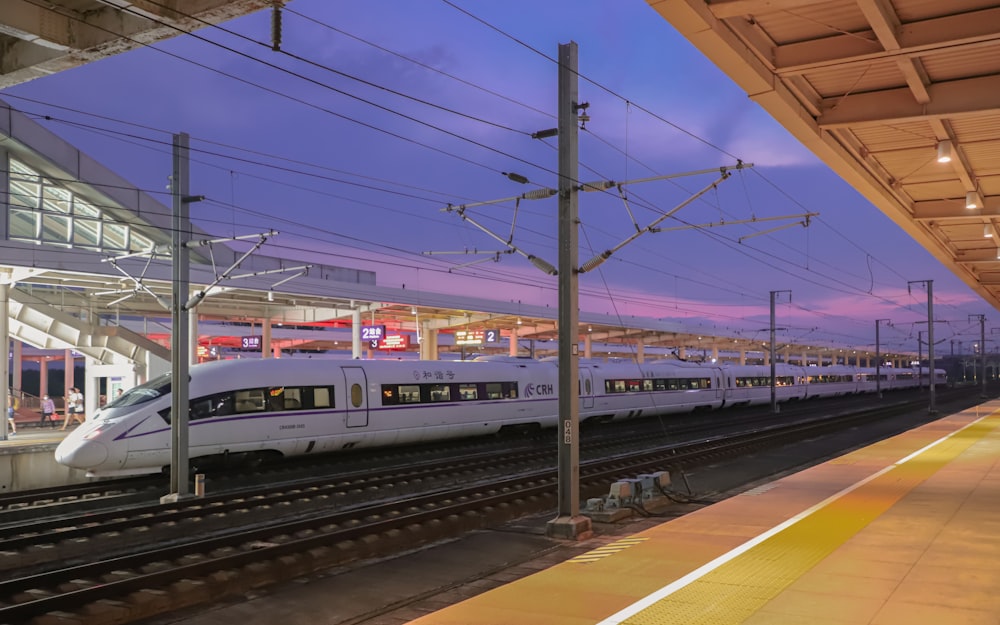 a white train pulling into a train station