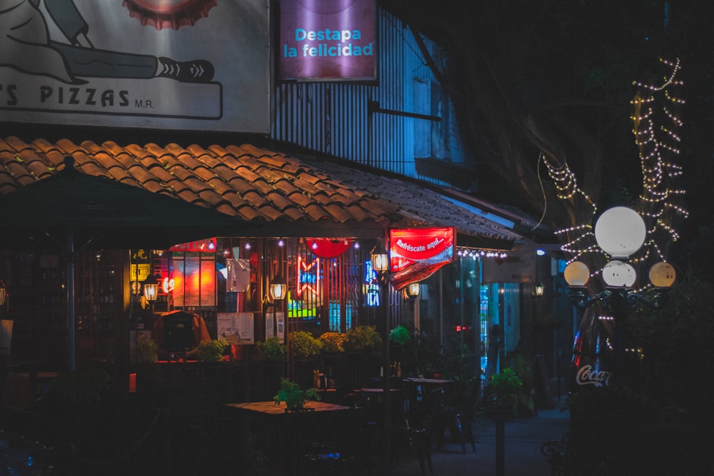 a restaurant at night lit up with colorful lights