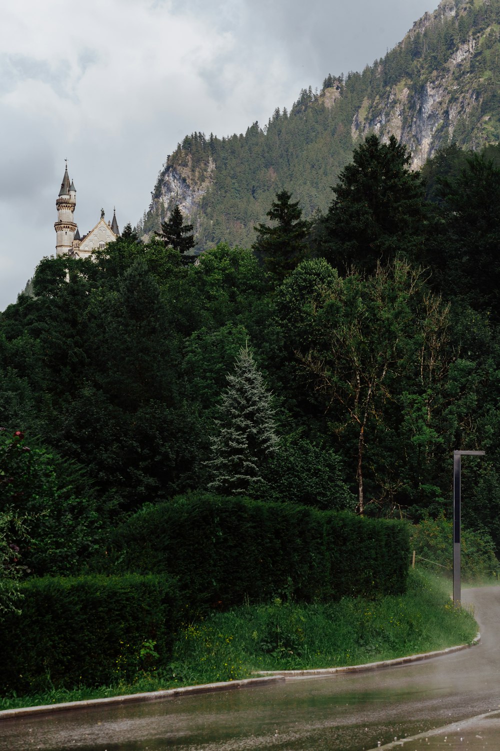 a very tall building sitting on top of a lush green hillside