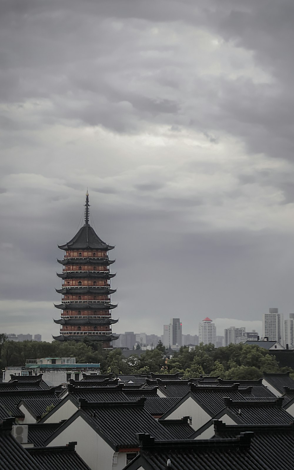 a tall tower towering over a city under a cloudy sky