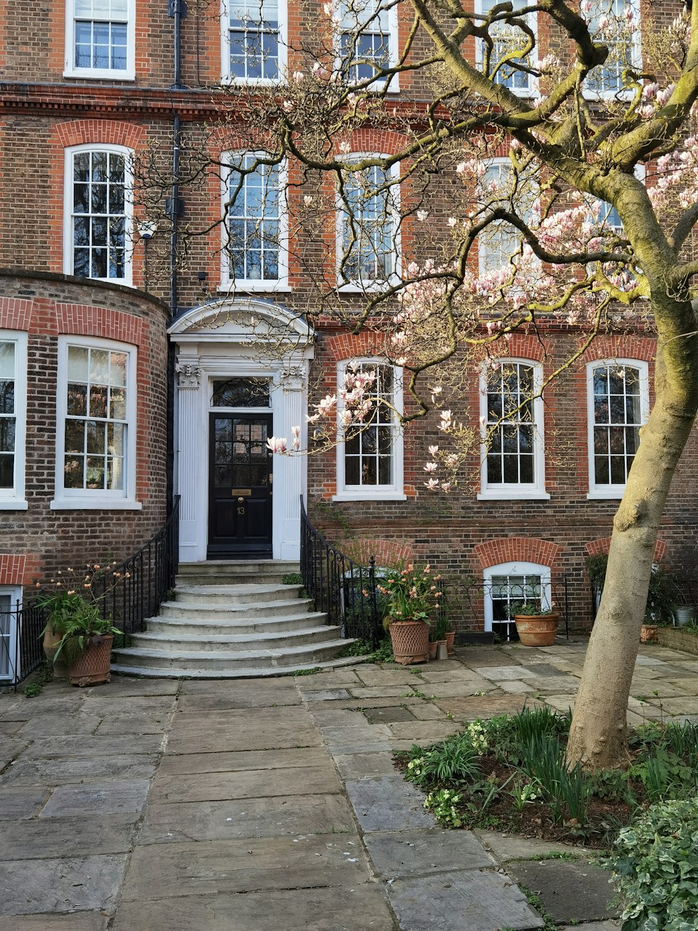 a large brick building with a tree in front of it