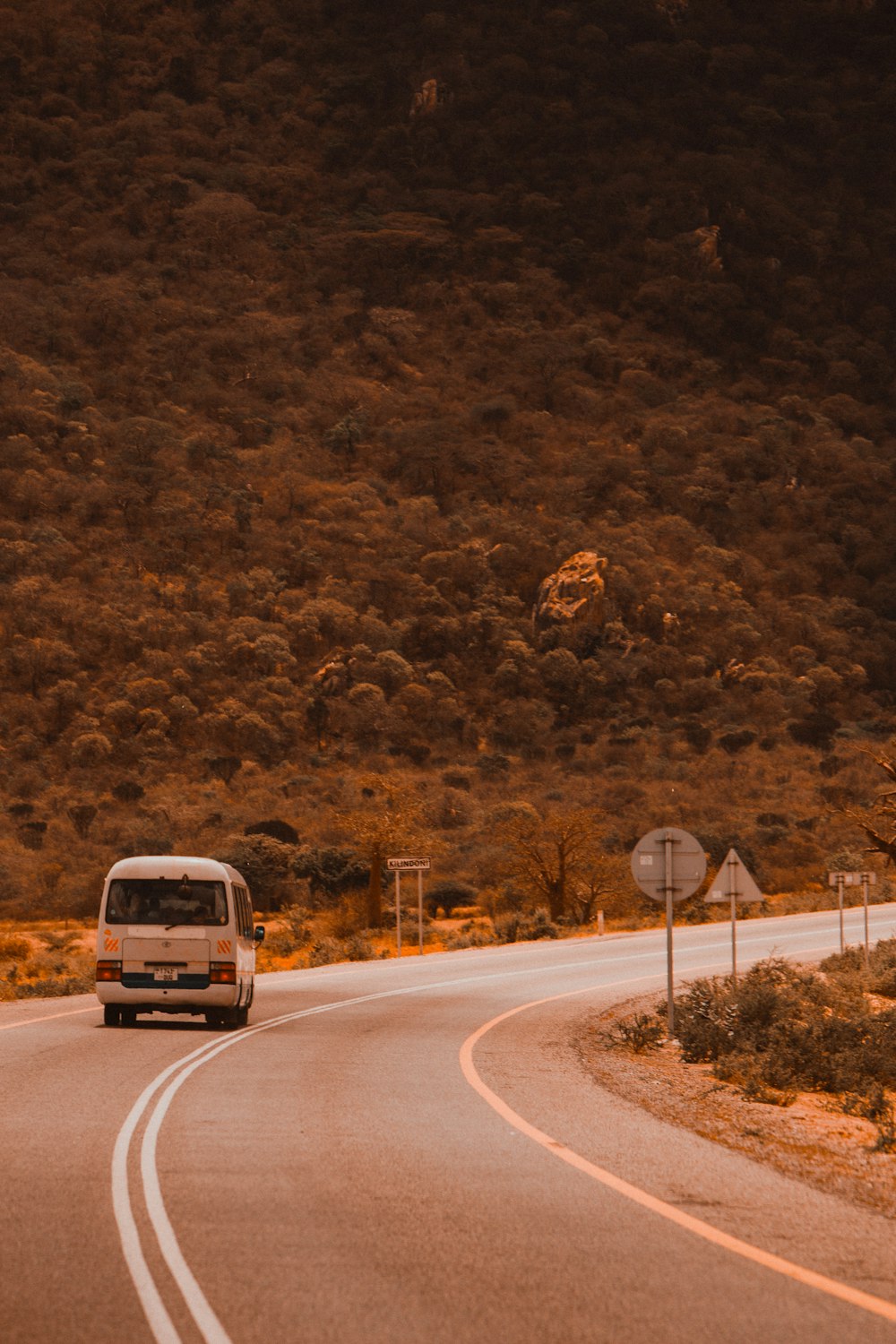 a van driving down a curvy road in the mountains