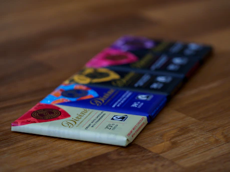 Close-up of glossy chocolate bars stacked neatly on a rustic wooden table.