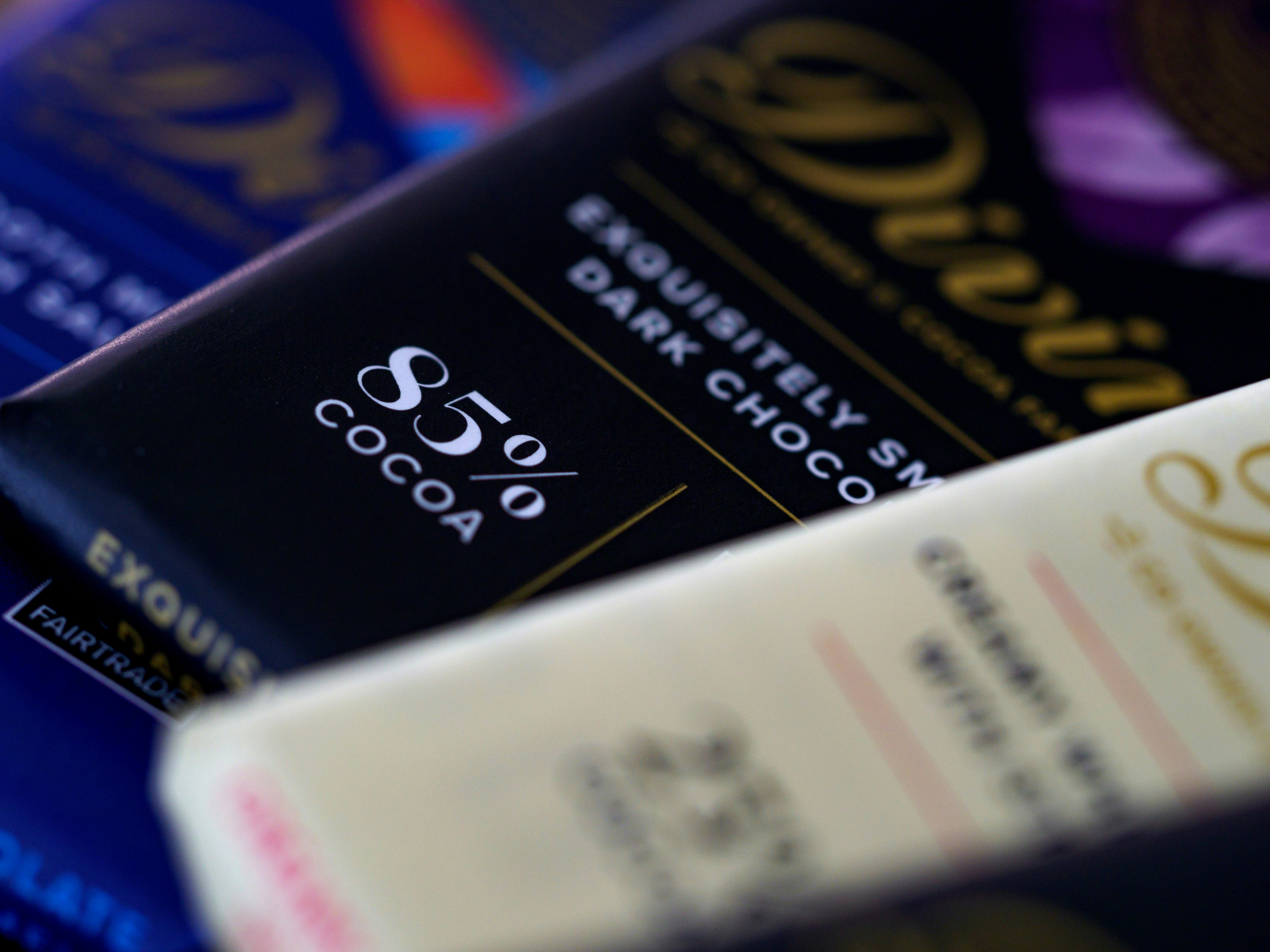 Close up of personalised chocolate favours with custom printed wrappers in pastel colours in warm light