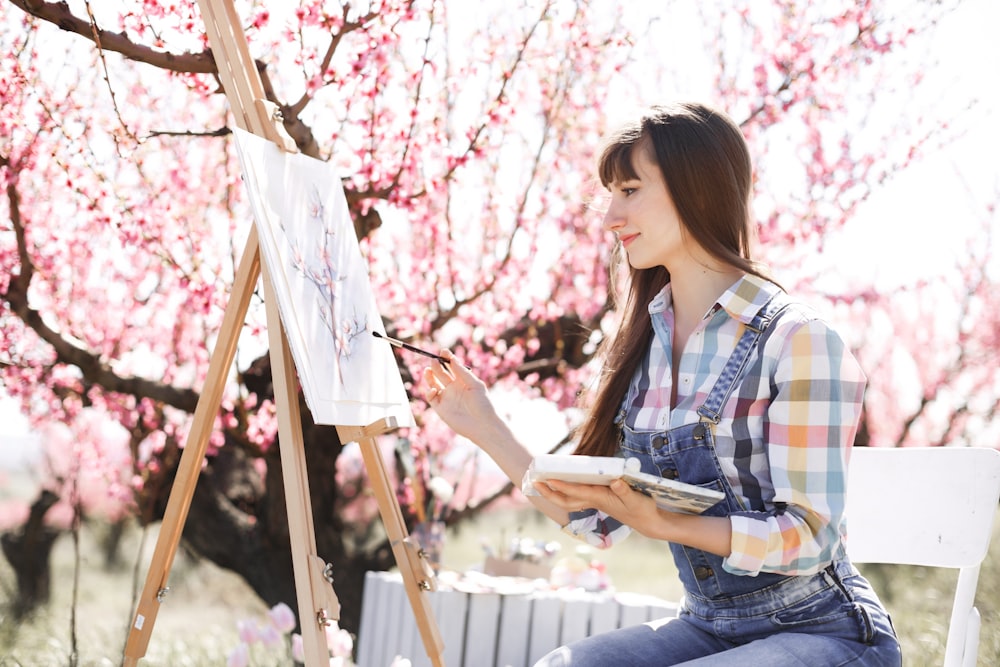 Una mujer sentada en un banco frente a un cuadro