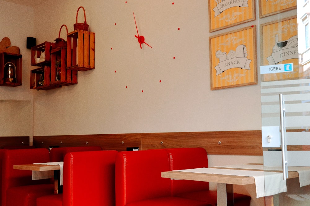 a restaurant with red booths and a clock on the wall