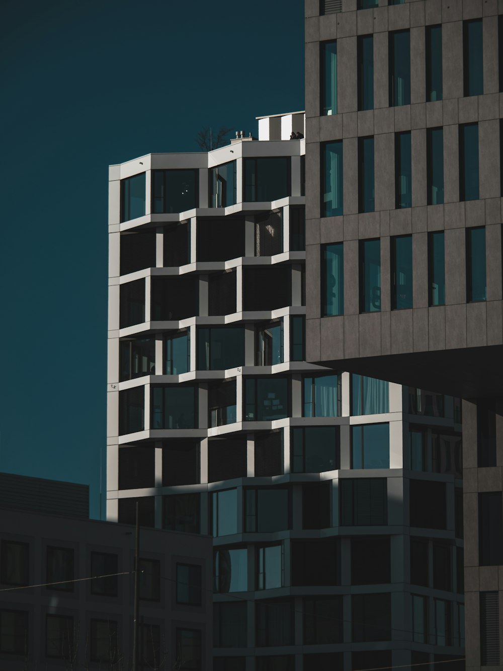 a tall building with lots of windows next to other buildings