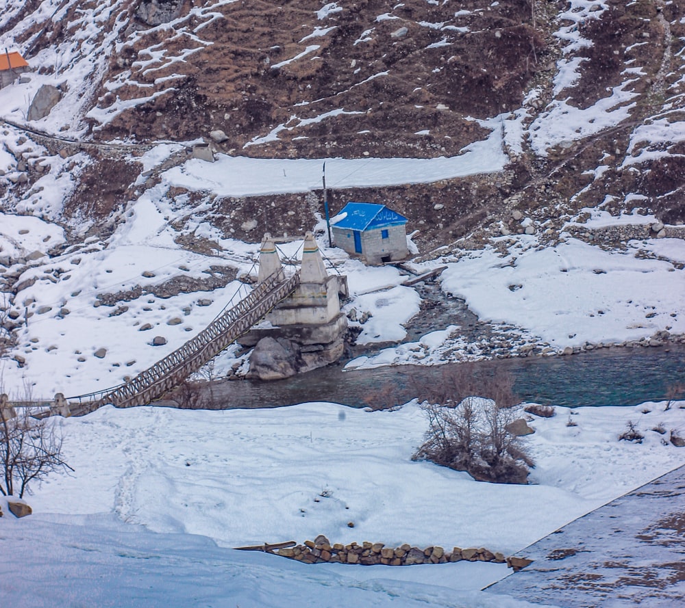 a snow covered mountain side with a bridge