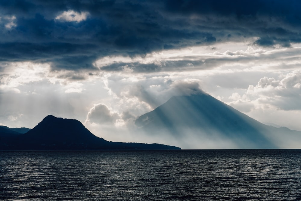 a large body of water with a mountain in the background