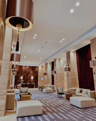 a hotel lobby with couches, chairs and a chandelier