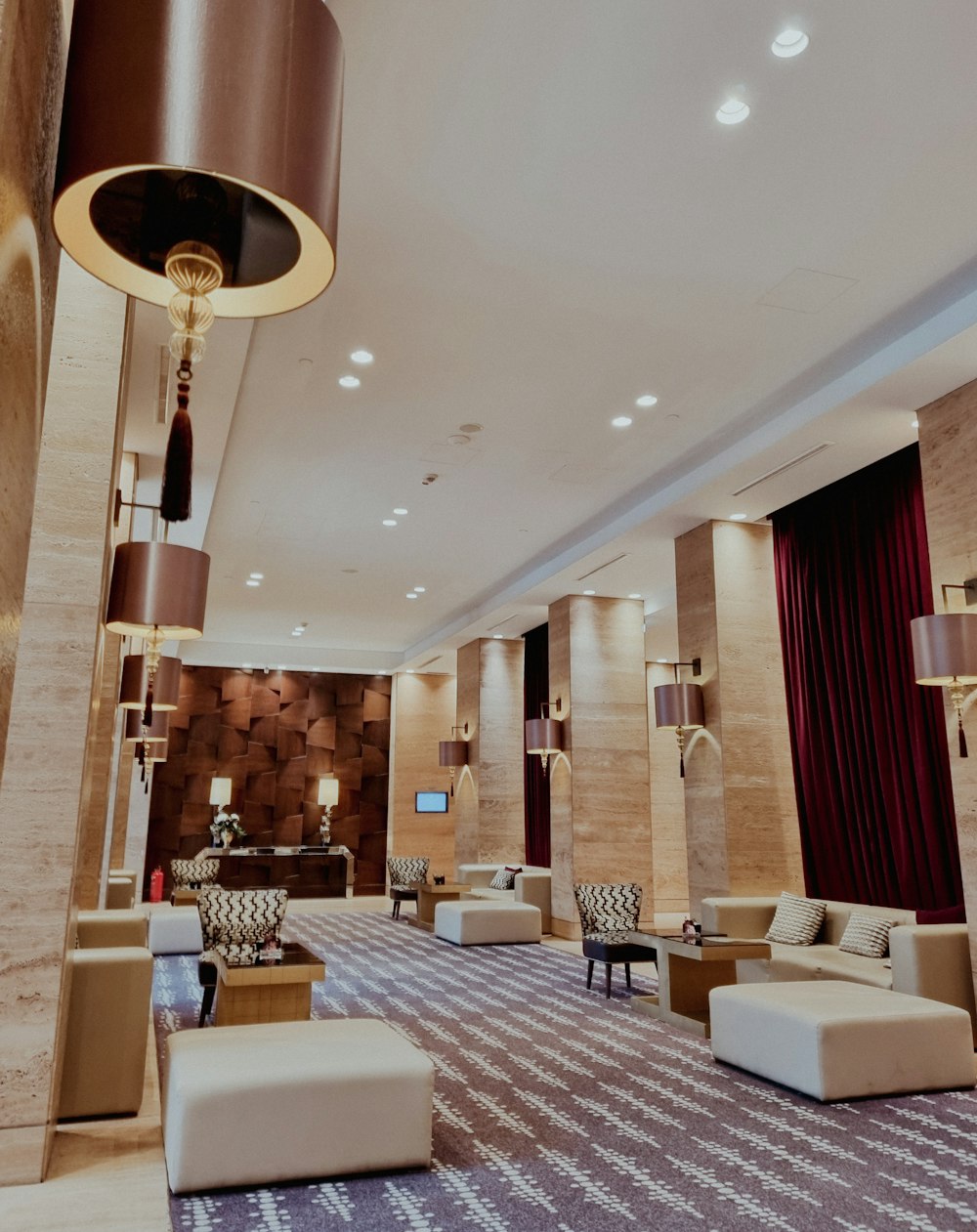 a hotel lobby with couches, chairs and a chandelier