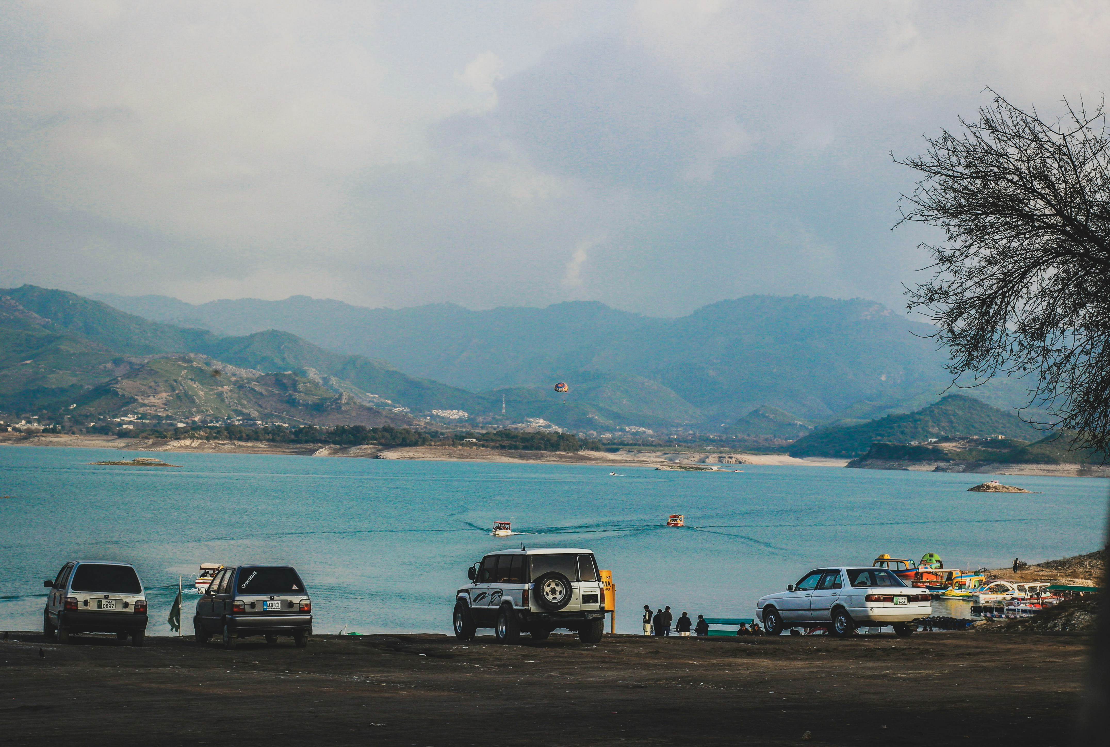 a group of cars parked next to a body of water