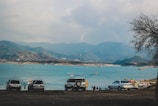 a group of cars parked next to a body of water