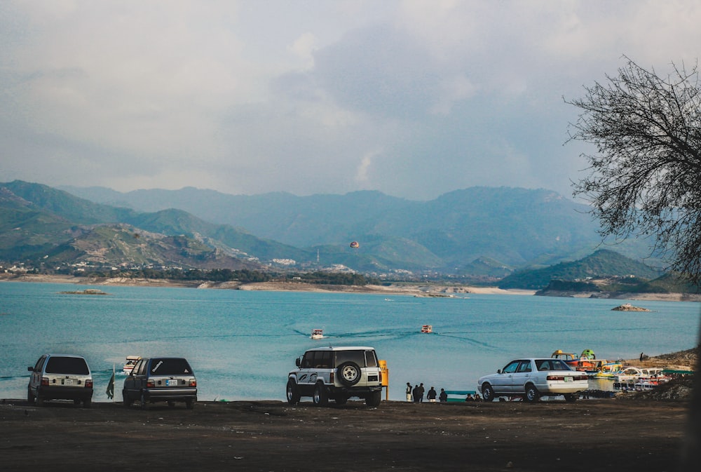 a group of cars parked next to a body of water