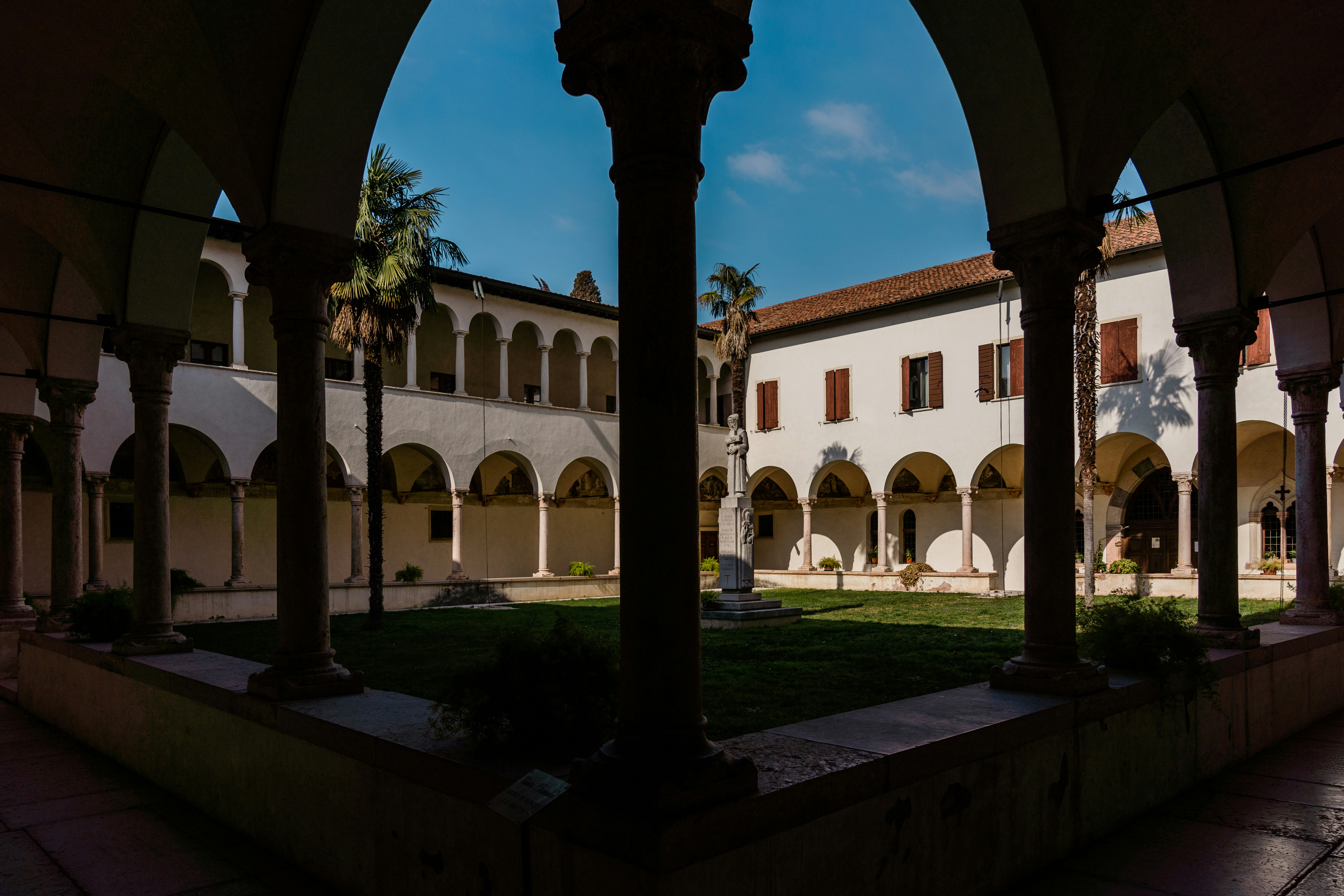 a courtyard with arches and a clock tower