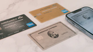a group of credit cards sitting next to a cell phone