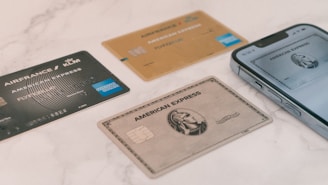 a group of credit cards sitting next to a cell phone